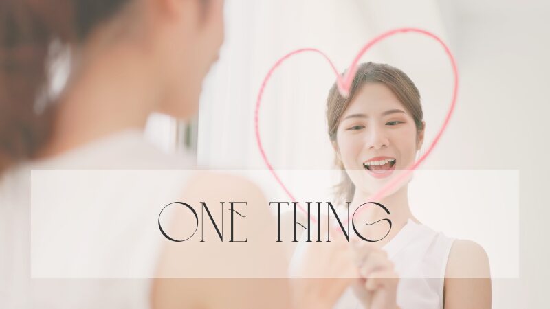 鏡に向かって口紅でハートを描く笑顔の女性